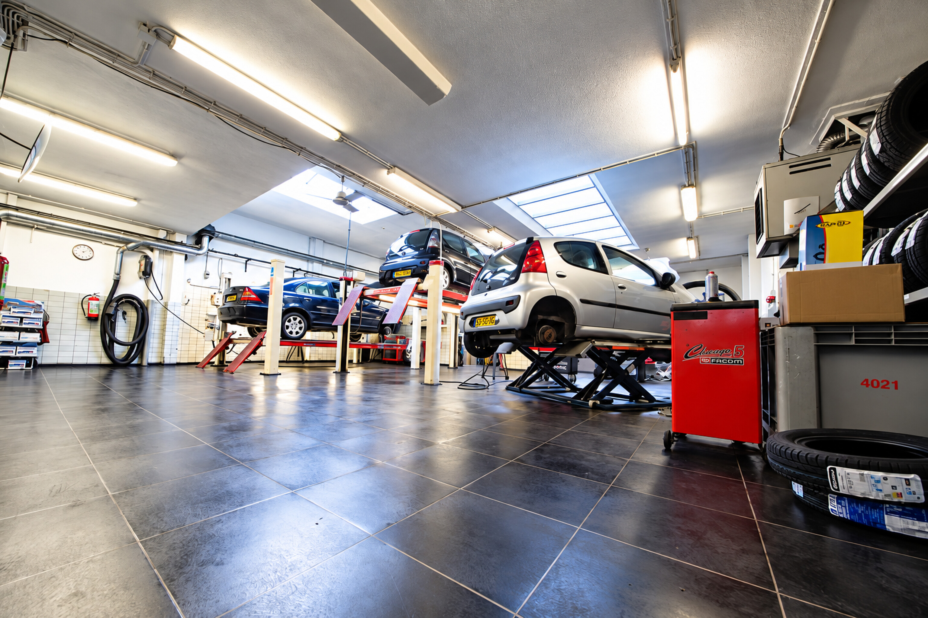 De werkplaats van Auto Haarlem met auto's op de hefbrug